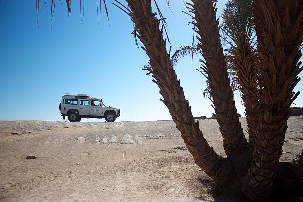 Car driving in the desert between sand dunes of the rub al Khali desert