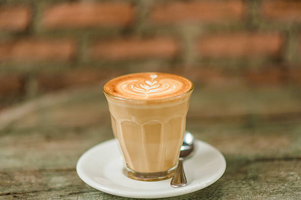 istock Cup of coffee with tree leaves pattern on wooden table 479305182