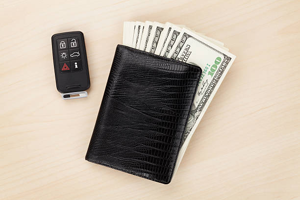 Money cash wallet and car remote key Money cash wallet and car remote key on wooden table car keys table stock pictures, royalty-free photos & images