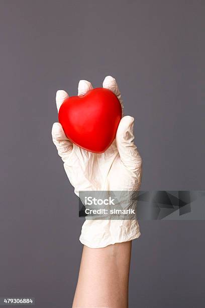 Doctor Holding Heart Stock Photo - Download Image Now - 2015, A Helping Hand, Accidents and Disasters