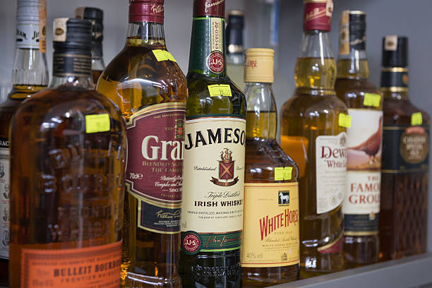 Alcohol Antalya, Turkey - February 12, 2014:Close-up shot different kinds of alcohol bottles on the market shelf are waiting to be purchased by consumers. The alcohol includes Bullet Bourbon, Grant's Jamescon, White Horse... Camera focus is on Jamescon. Jameson Irish Whiskey is produced by Pernod Ricard and is the largest selling Irish Whiskey in the world. uffington horse stock pictures, royalty-free photos & images