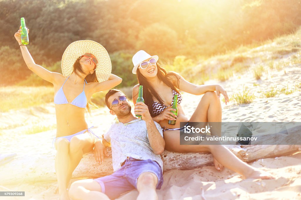 Friends on the beach Friends on the beach drinking beer. Beach party. 20-29 Years Stock Photo