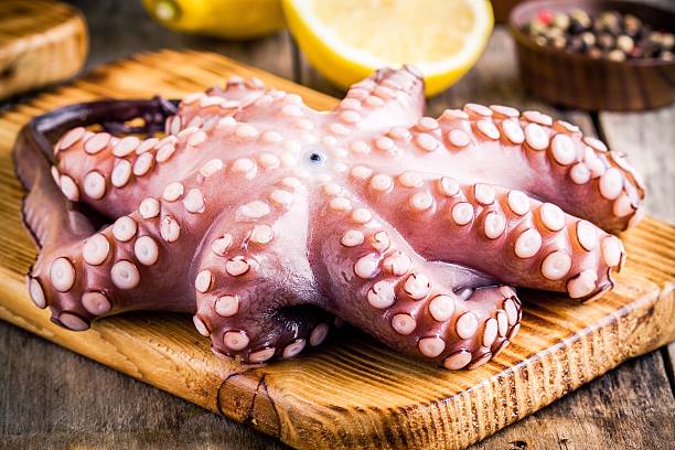 istock whole raw octopus on cutting board with lemon and pepper 479310784