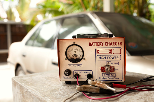 Car battery charger with a car at the background