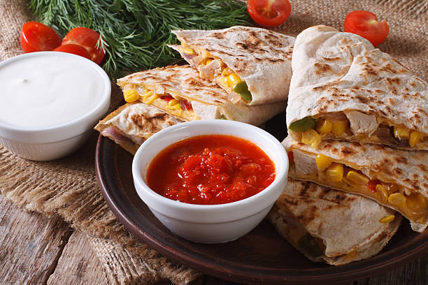 istock Quesadilla sliced with vegetables, chicken closeup and sauces 479318212