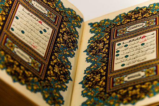 Photo of the Sheets entire Qoran - Koran - Qur'an with the name of Allah, reading and lokinng into Qoran - Koran - Qur'an