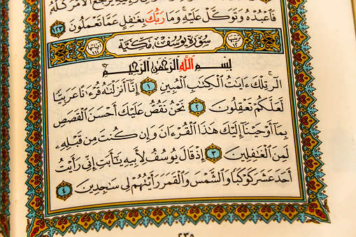 Photo of the Sheets entire Qoran - Koran - Qur'an with the name of Allah, reading and lokinng into Qoran - Koran - Qur'an