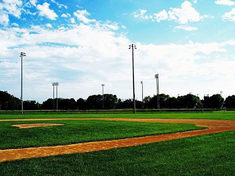This is a gorgeous photograph of a baseball diamond in the summertime.