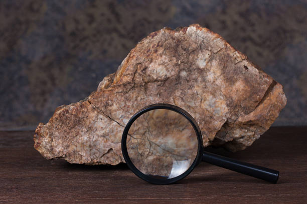 istock stone and magnifying glass on wood table. 479339327