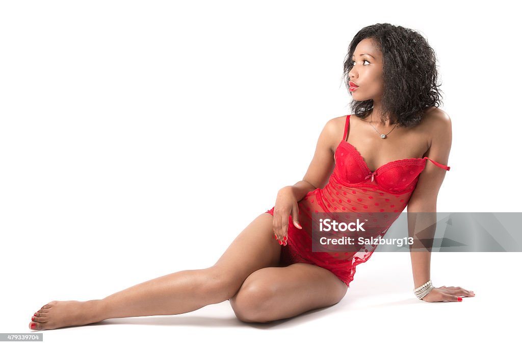 She's a African Queen Studio shot of an attractive African model in red lingerie sitting on the floor Lingerie Stock Photo