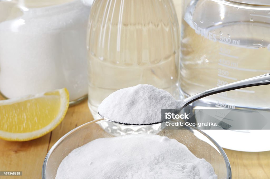 Natural cleaners. Vinegar, baking soda, salt and lemon. Eco-friendly natural cleaners. Vinegar, baking soda, salt, lemon and cloth on wooden table. Homemade green cleaning. Baking Soda Stock Photo