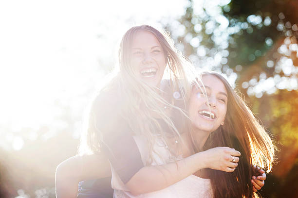zwei teenager lachen im park - beauty in nature women beautiful human teeth stock-fotos und bilder
