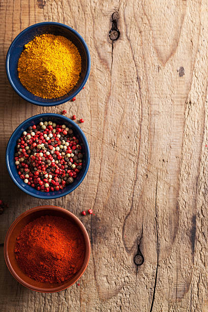 istock spices background: pink and black pepper, paprika powder, curry 479352371