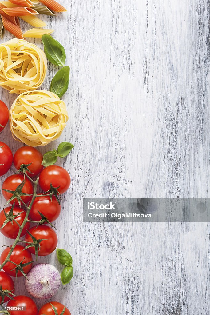 ingredients pasta tomatoes basil frame on white wooden backgroun ingredients pasta tomatoes basil frame on white wooden background Backgrounds Stock Photo