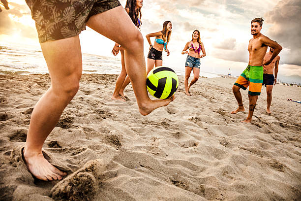 Friends playing soccer on the beach