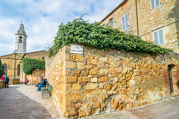 Pienza, Italy - January 25, 2015: street view of historic centre with tourists in Pienza, Italy. In 2004 the Val dOrcia was added to the UNESCO list of World Heritage Sites.