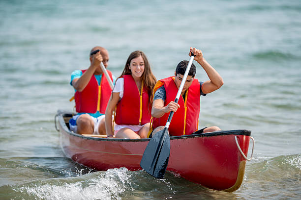 giovani adolescenti su una gita in canoa - canoeing people traveling camping couple foto e immagini stock