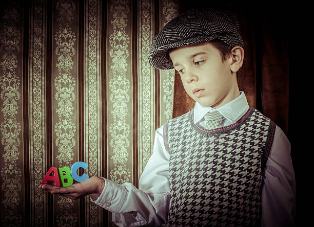Child in vintage clothes hold multicolor letters a b c