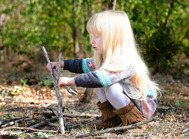 istock Cute Blond Girl Playing with Twigs on Ground 479373618