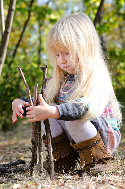 istock Cute Little Girl Playing with Dry Sticks 479373632