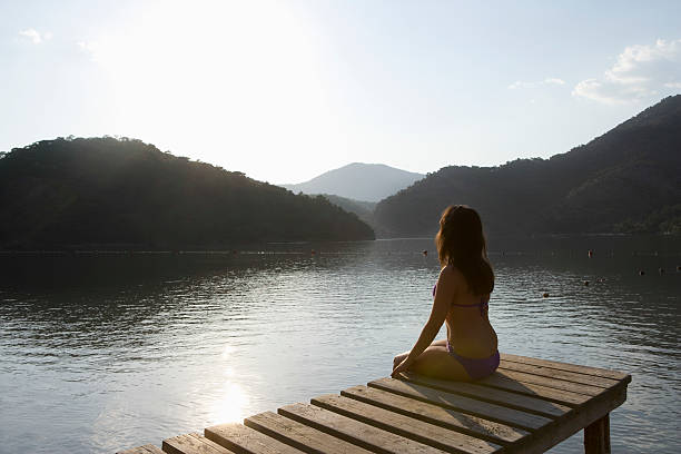 istock Woman Sitting On Lakeside Jetty At Dawn 479376669