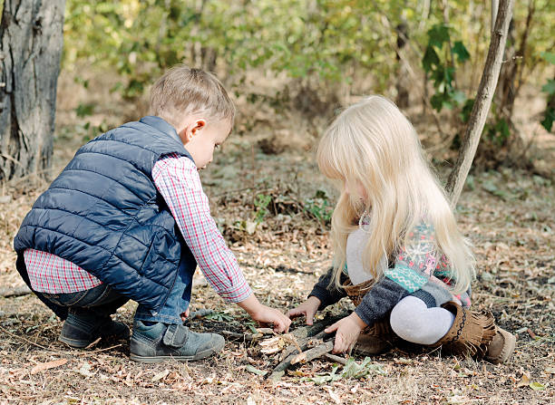 istock Cute Toddlers Playing with Dry Sticks on Ground 479376788