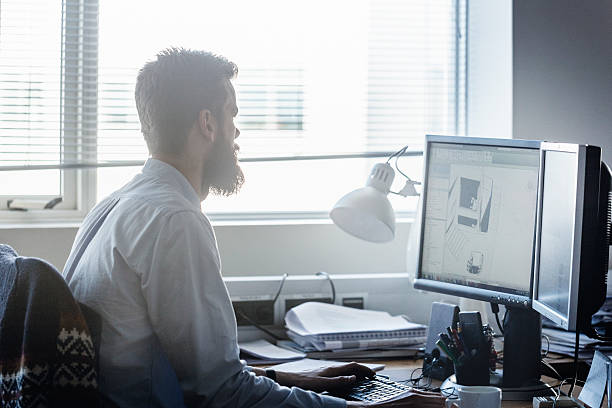 istock Side view of businessman using computer in brightly lit office 479377756