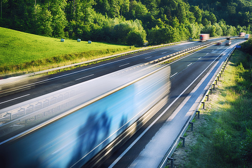 American truck speeding on freeway, blurred motion. Vibrant colors, fast transport, tourist travel.
