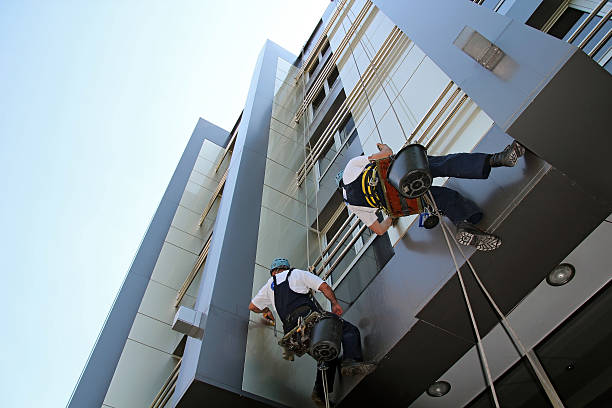 Facade Cleaning- Glass Cleaning Services Workers washing the windows facade of a modern office building. skyscraper office building built structure new york city stock pictures, royalty-free photos & images