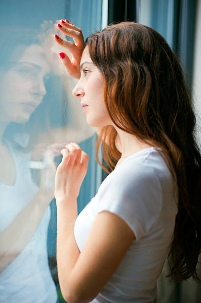 istock beautiful girl at window 479396537