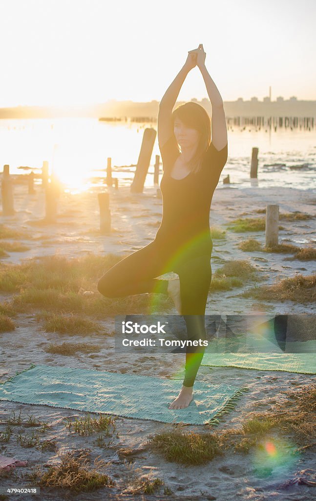 Yoga series young girl doing yoga exercise alone on the seaside. 20-24 Years Stock Photo