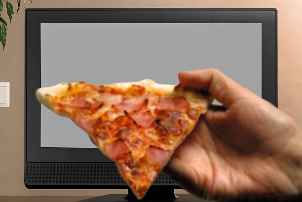 istock Man hand with pizza slice watching TV 479403037