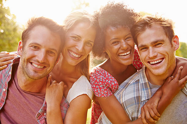 istock Two happy couples embracing and smiling to camera outdoors 479409016
