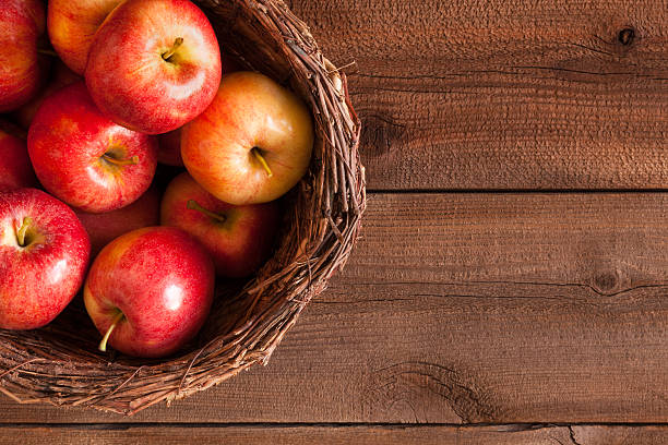 istock Pile of red apples in rustic basket on wood (P) 479409852