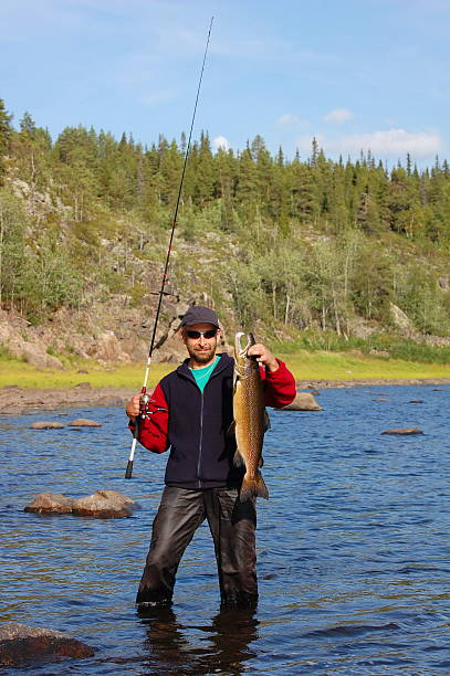 istock Fisherman caught a salmon in the north river. 479410120