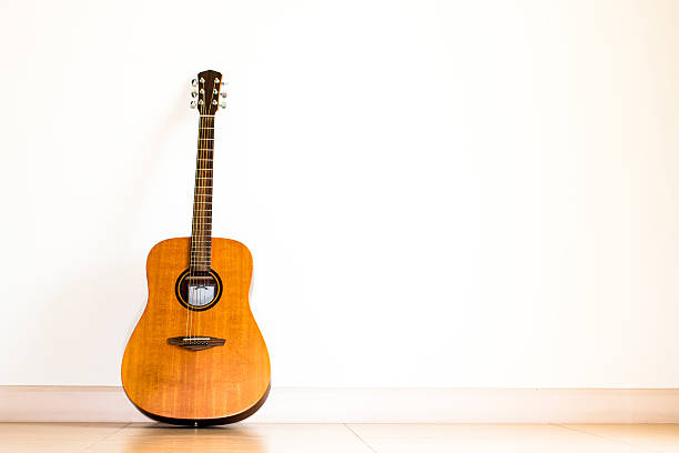istock Acoustic guitar standing in white room background 479412538