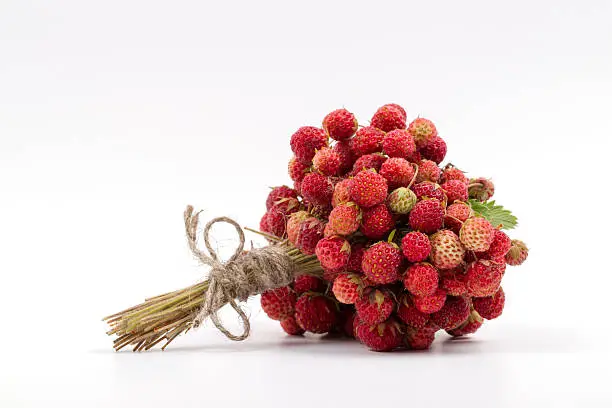 Fragrant bouquet of mature wild strawberry on a white background.