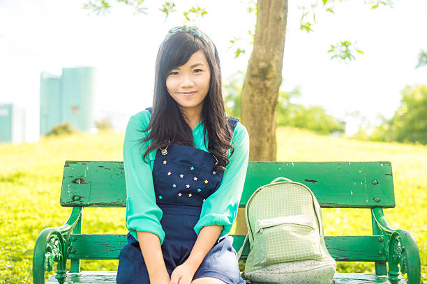 istock Attractive young asian woman sitting on bench 479430108