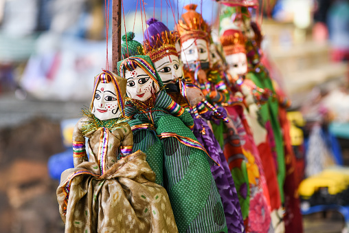 hand made puppets attached to string in India dolls. female   puppets wearing Indian traditional saree/sari and makeup. female attached to string dancing