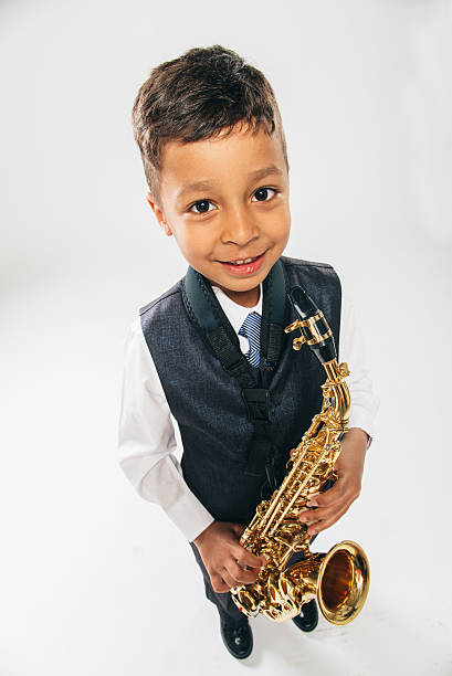 istock six years old boy plays saxophone at studio 479431656