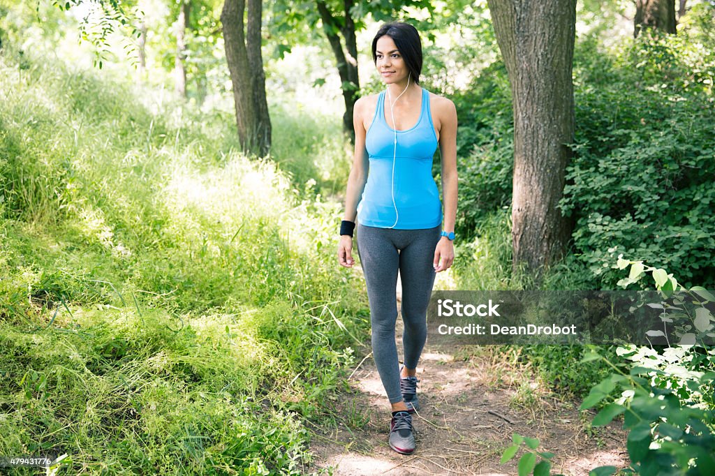 Happy sports woman wlaking outdoors Full length portrait of a happy sports woman wlaking outdoors in the park 2015 Stock Photo