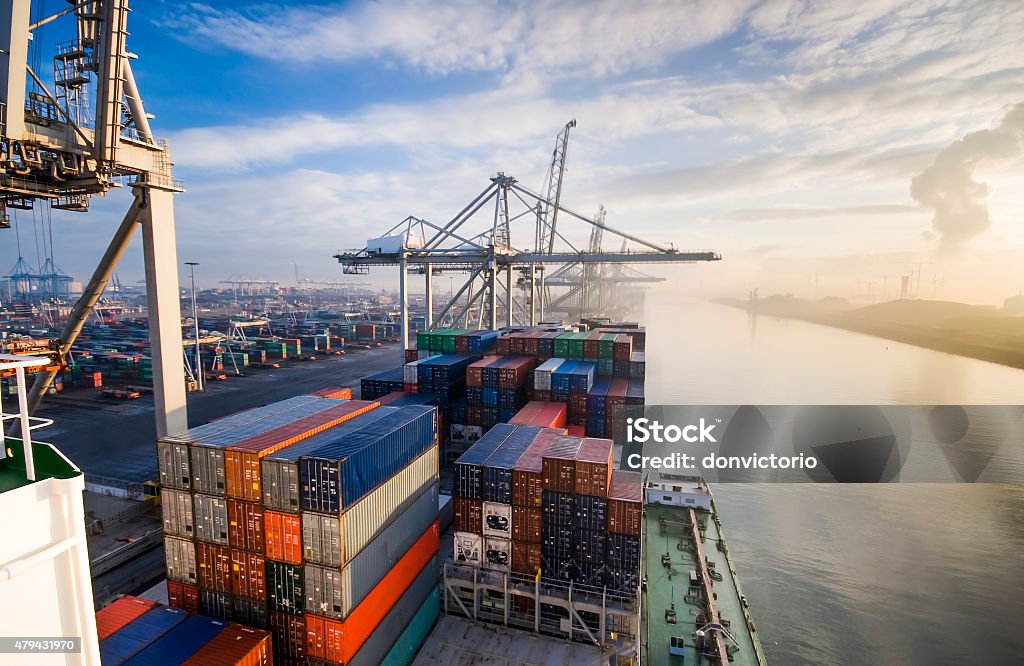 Container operation in port. Sunrise in busy container terminal in Rotterdam, Netherlands. Harbor Stock Photo