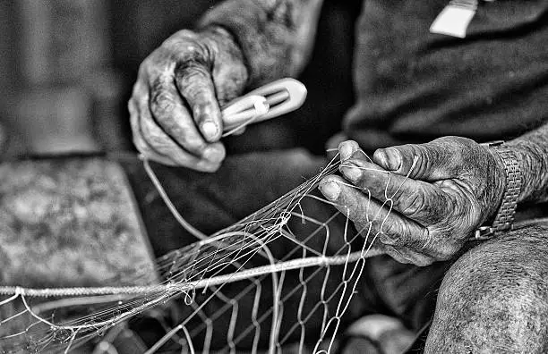 Old fisherman's village of Trani intent to mend fishing nets