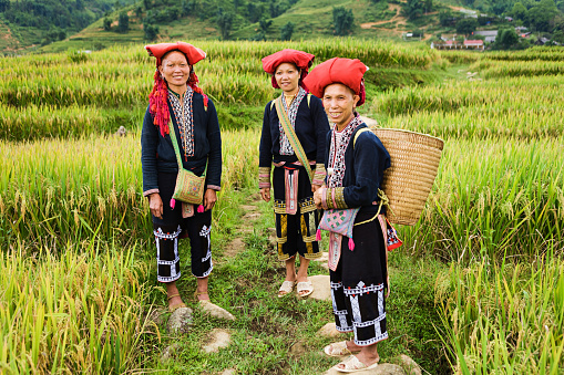 Red Dao women usually wear a long blouse over trousers and traditional red hat.