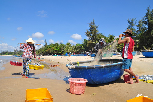 Lagi, Vietnam - February 26, 2012: Local fishermen are preparing their fishing nets for a new working day in the Lagi beach