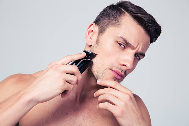 istock Handsome man shaving with electric razor 479441496