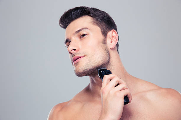 istock Young man shaving with electric razor 479441518