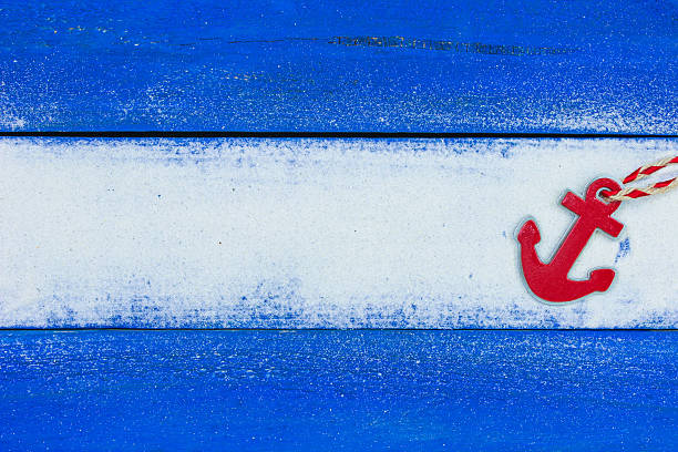 Blank rustic wooden ocean blue beach sign with sand texture and red anchor with rope