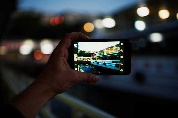 istock Male hand holding a phone which makes photo yachts 479443606
