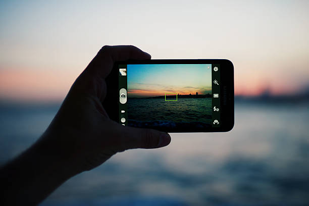 istock Person taking a photo of  sunset using smart phone camera 479443872